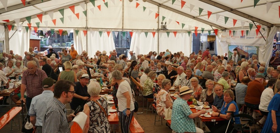 Viele Seniorinnen und Senioren gemeinsam im Zelt beim Stein- und Burgfest