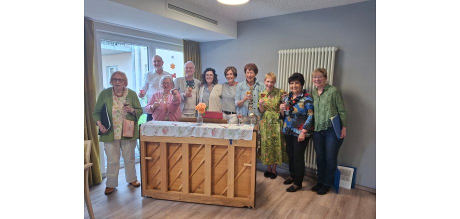 Viele Menschen stehen gemeinsam vor einem Klavier