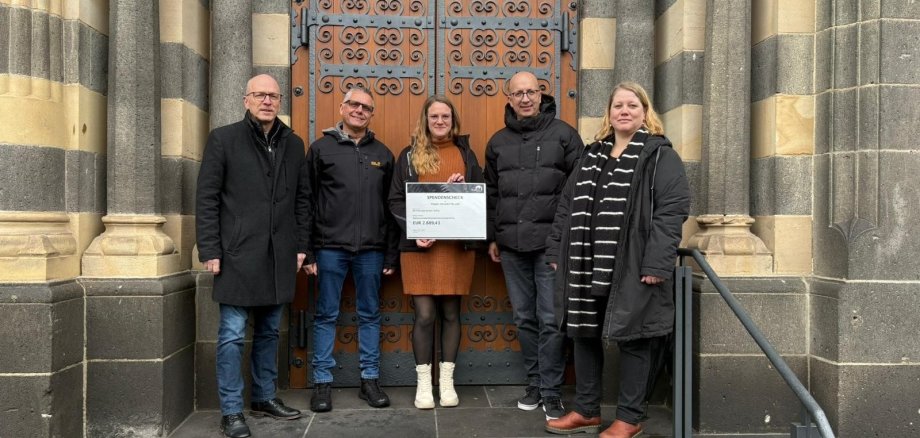 v.l.n.r.: Oberbürgermeister Dirk Meid, Projektmitarbeiter Ralf Piesack, Stellv. Verwaltungsleiterin BFS Laura Wassong, Direktor Teilhabe Manuel Quint, Projektmitarbeiterin Nicole Carlsen Oberbürgermeister Dirk Meid, Projektmitarbeiter Ralf Piesack, Stellv. Verwaltungsleiterin BFS Laura Wassong, Direktor Teilhabe Manuel Quint, Projektmitarbeiterin Nicole Carlsen stehen gemeinsam auf der Treppe vor der Herz Jesu Kirche