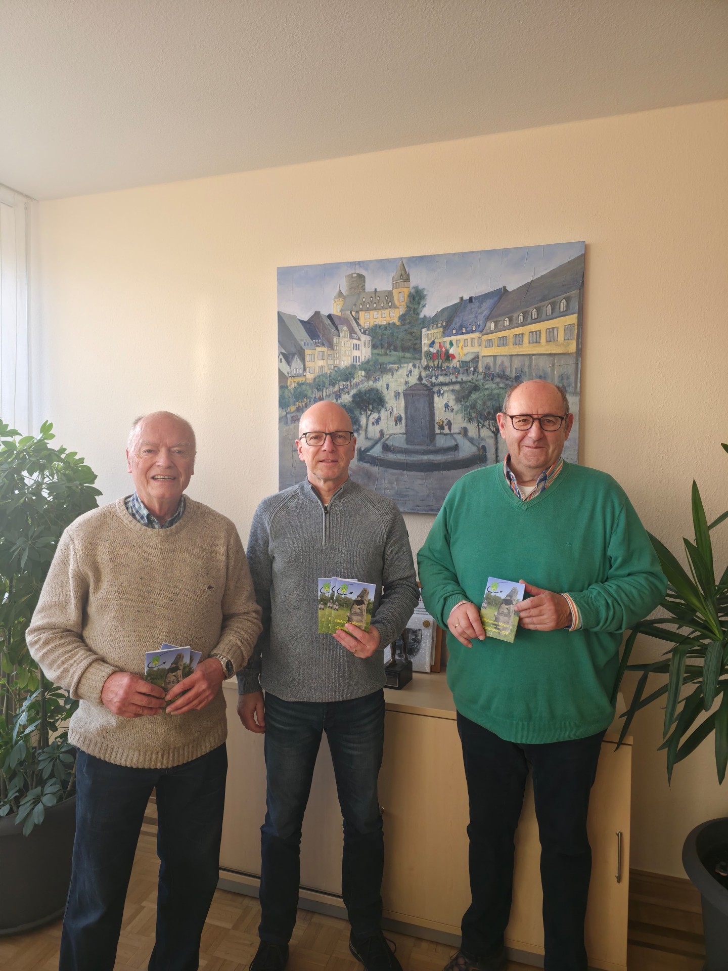 stellvertretender Vorsitzender Walter Reis, Oberbürgermeister Dirk Meid, Vorsitzender Joachim Rogalski stehen nebeneinander und halten jeweils einen Wanderplan in der Hand