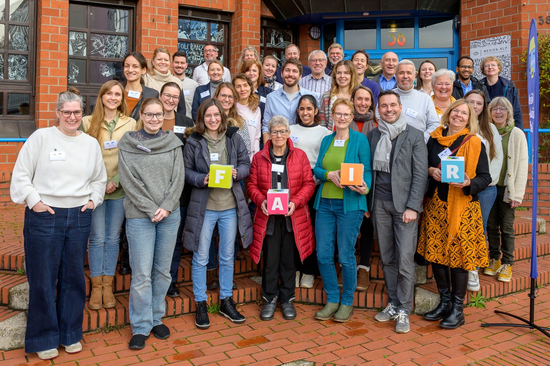Viele Menschen stehen gemeinsam vor einem Eingang