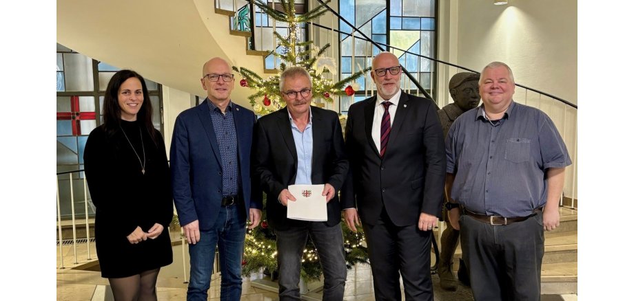 v.l.n.r.: Büroleitung Jasmin Alter, Oberbürgermeister Dirk Meid, Robert Dewald, Fachbereichsleiter Uwe Hoffmann und Personalratsvorsitzender Wolfgang Goeken Büroleitung Jasmin Alter, Oberbürgermeister Dirk Meid, Robert Dewald, Fachbereichsleiter Uwe Hoffmann und Personalratsvorsitzender Wolfgang Goeken stehen gemeinsam vor dem festlich geschmückten Tannenbaum in der Verwaltung