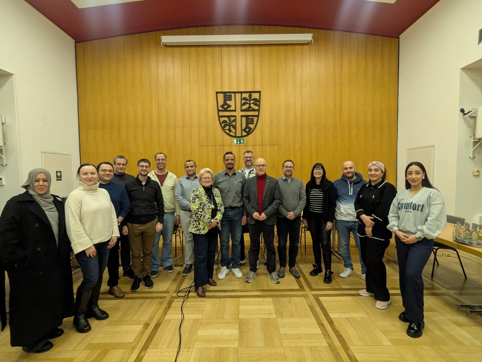 Viele Menschen stehen nebeneinander im Sitzungssaal