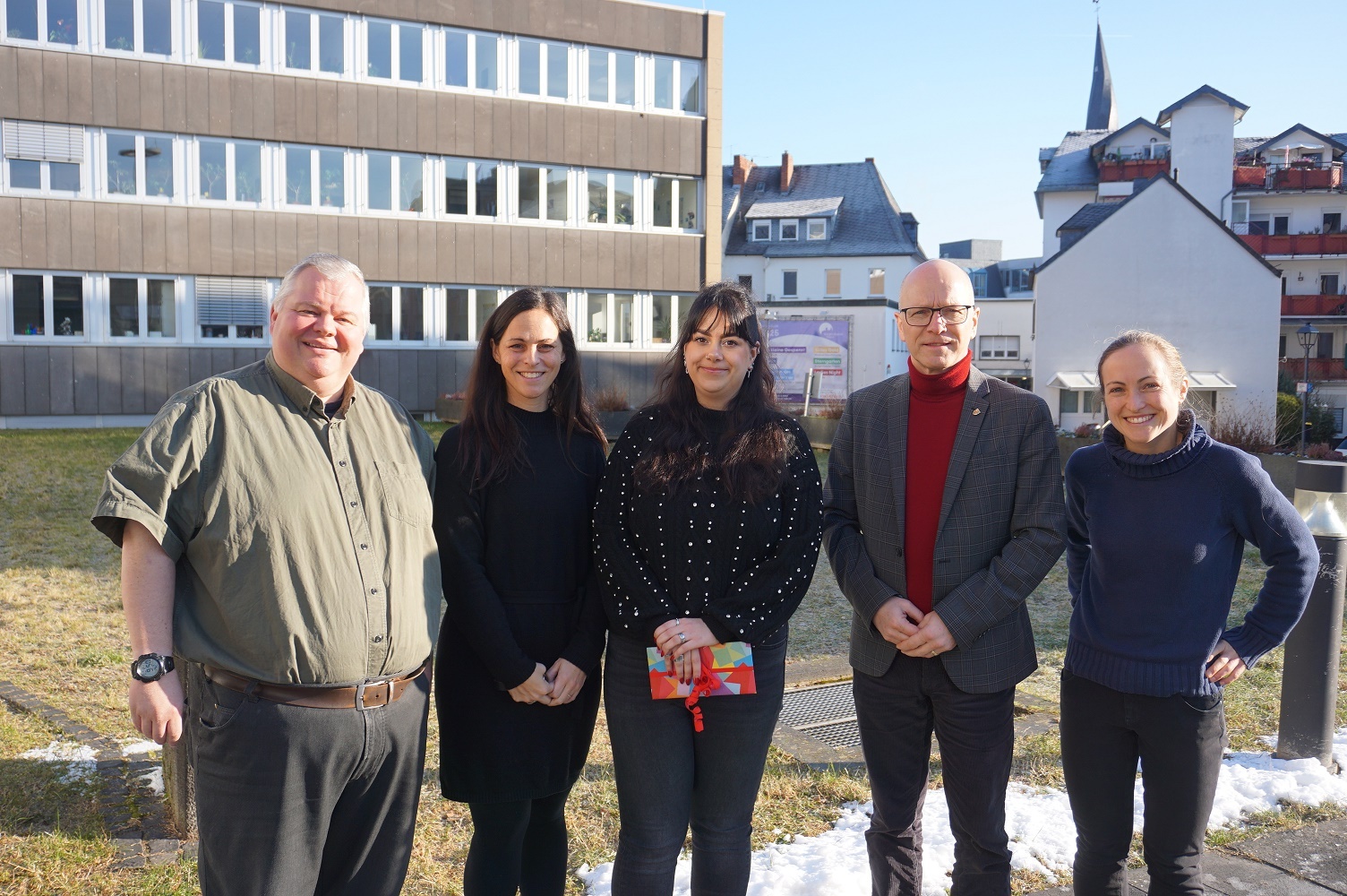 Fünf Personen stehen draußen vor Rathaus