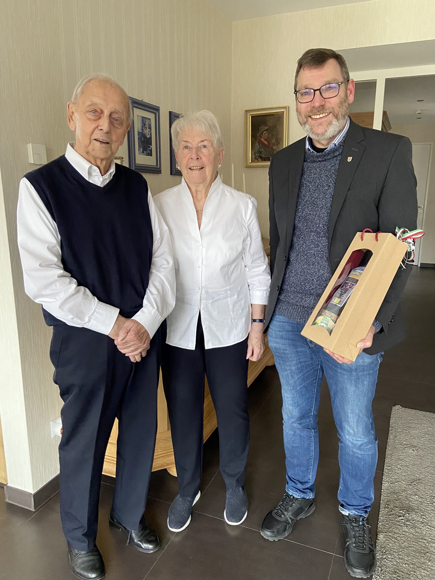 Zwei Männer und eine Frau stehen zu einem Foto zusammen