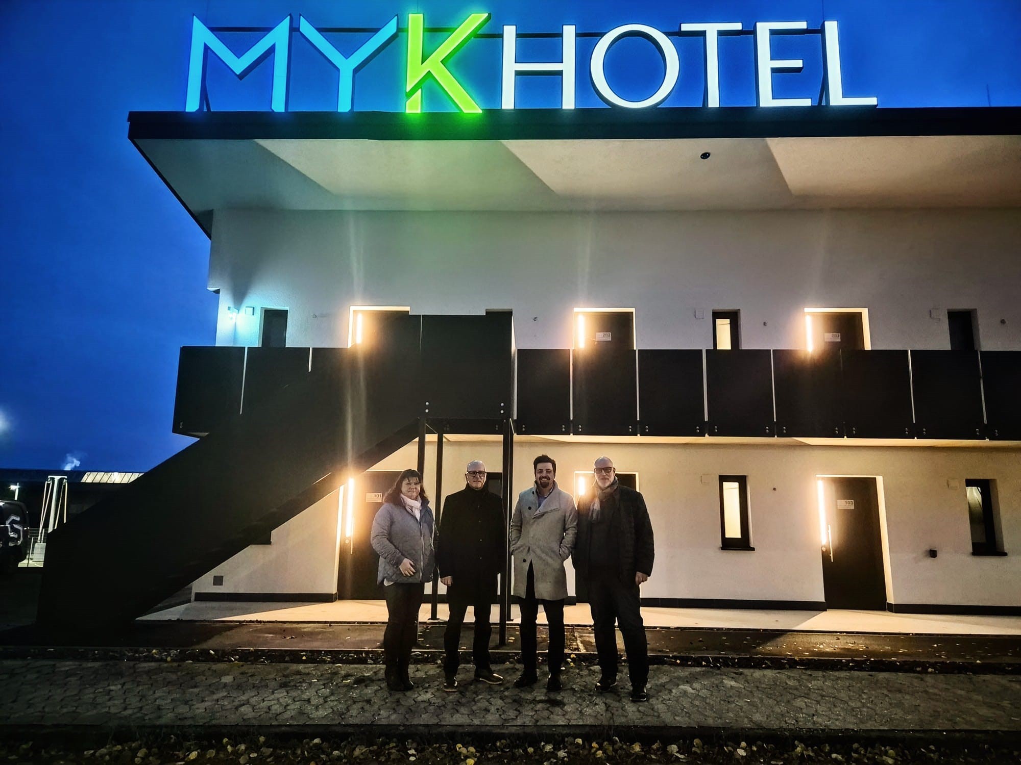 4 Personen stehen vor einem Hotel