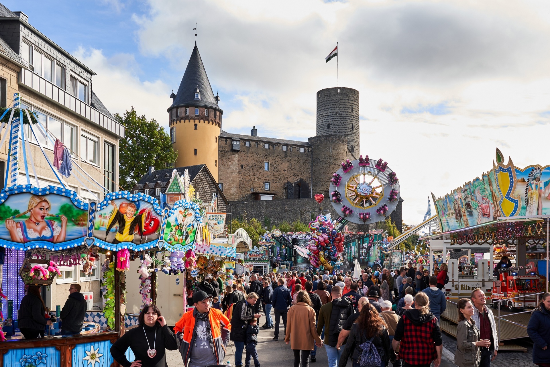 Ein gut besuchter Jahrmarkt - im Hintergrund die Burg