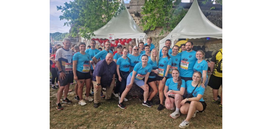 Viele motivierte Mitarbeiterinnen und Mitarbeiter posieren gemeinsam auf dem Bild.