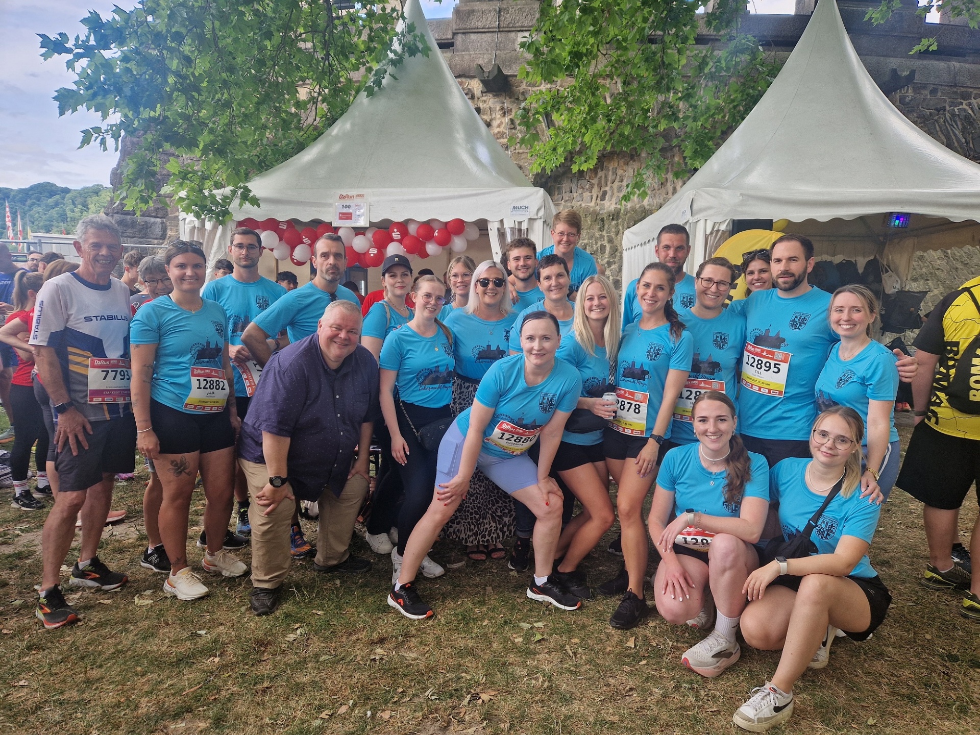 Viele motivierte Mitarbeiterinnen und Mitarbeiter posieren gemeinsam auf dem Bild.