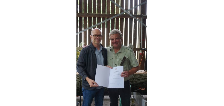 Oberbürgermeister Dirk Meid und Peter Göke bei der Feierstunde Zwei Personen stehen für ein Foto zusammen - einer hält eine Urkunde in der Hand