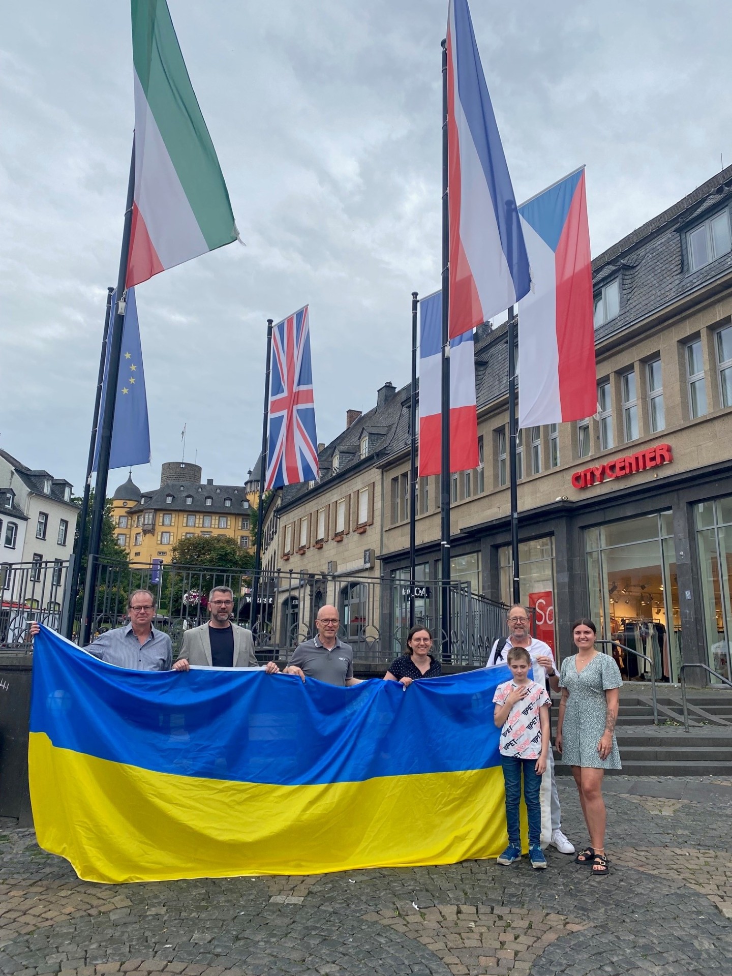 Mehrere Menschen halten eine große Flagge in der Hand