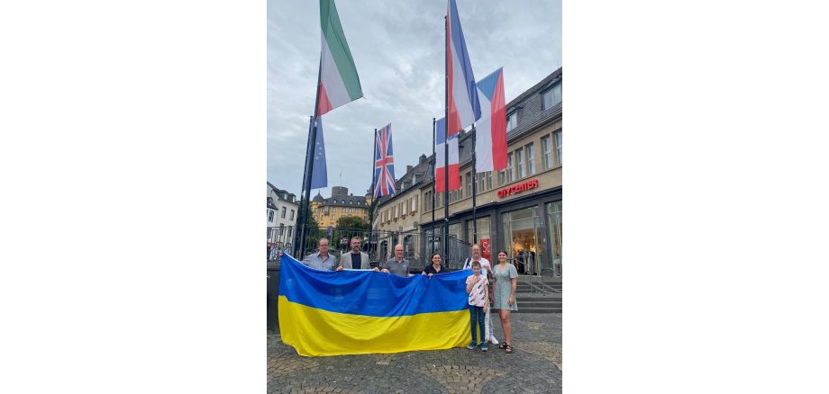 v.l.n.r.: Burkhard Vielhaber (Mitglied Freundschaftskreis), Oliver Schick (Mitglied Freundschaftskreis), Oberbürgermeister Dirk Meid, Juliane Hertel (Mitglied Freundschaftskreis), Helmut Sondermann (Mitglied Freundschaftskreis), stellv. Bereichsleitung Julia Judt Mehrere Menschen halten eine große Flagge in der Hand
