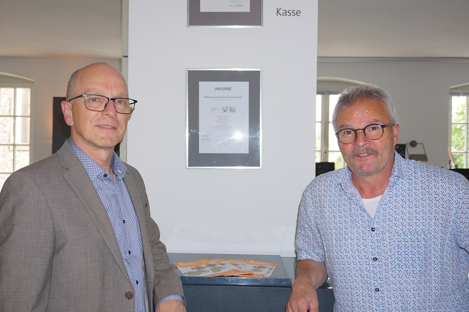 Oberbürgermeister Dirk Meid und Robert Dewald, stellvertretender Bereichsleiter, freue sich über die erneute Auszeichnung Zwei Männer stehen vor einer eingerahmten Urkunde