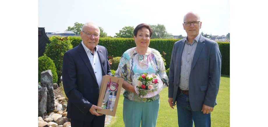 3 Personen stehen für ein Foto zusammen