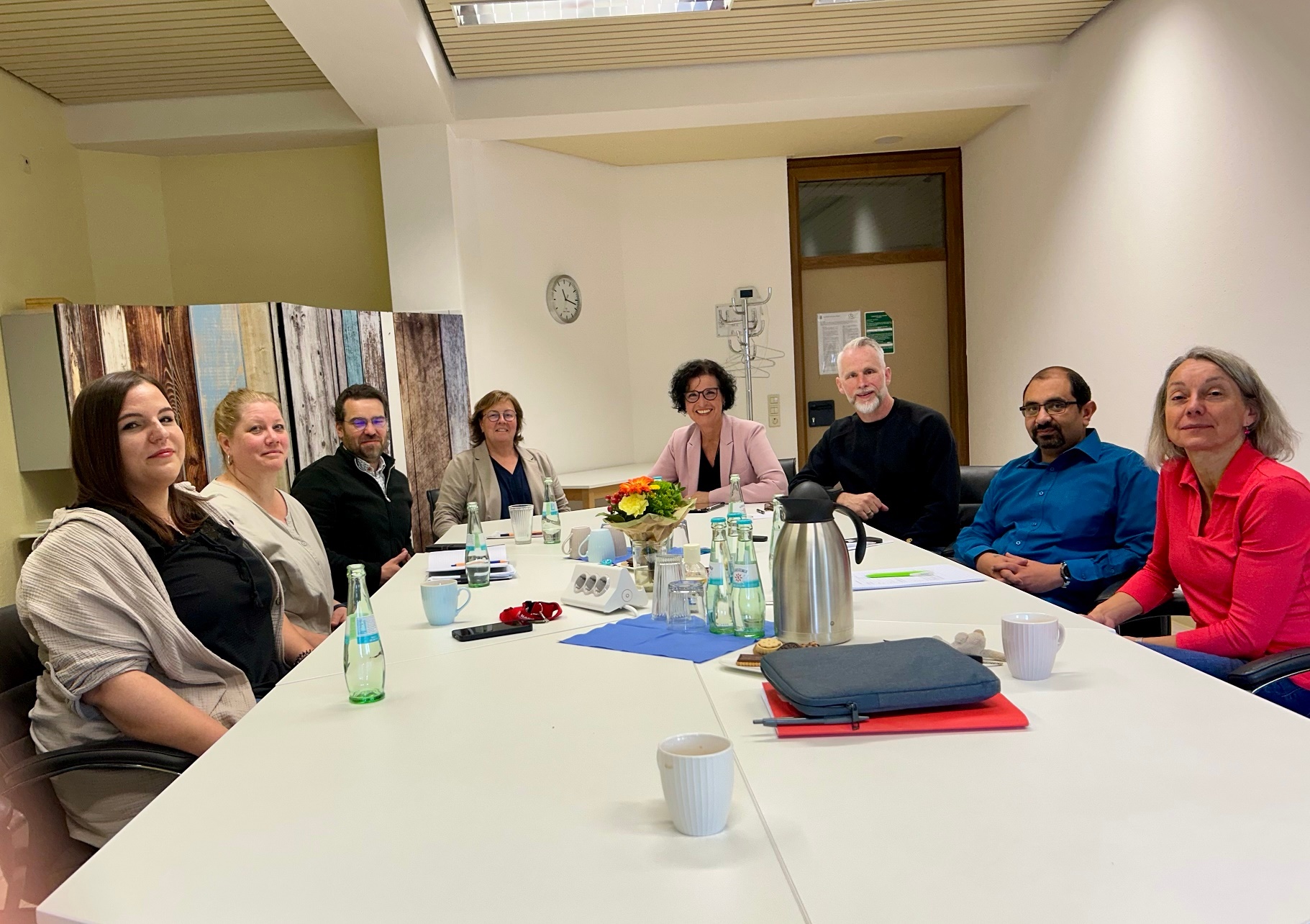 Mehrere Menschen sitzen an einem großen Tisch zusammen