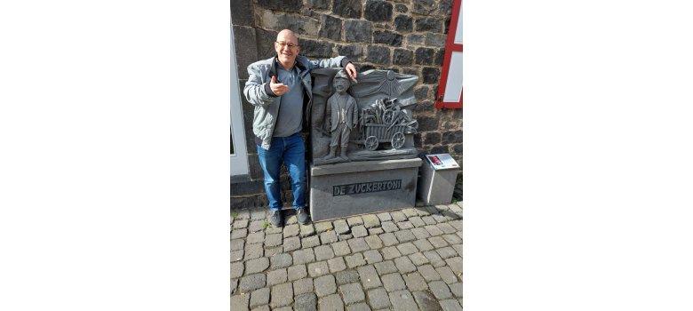 Mann vor einer Steinfigur