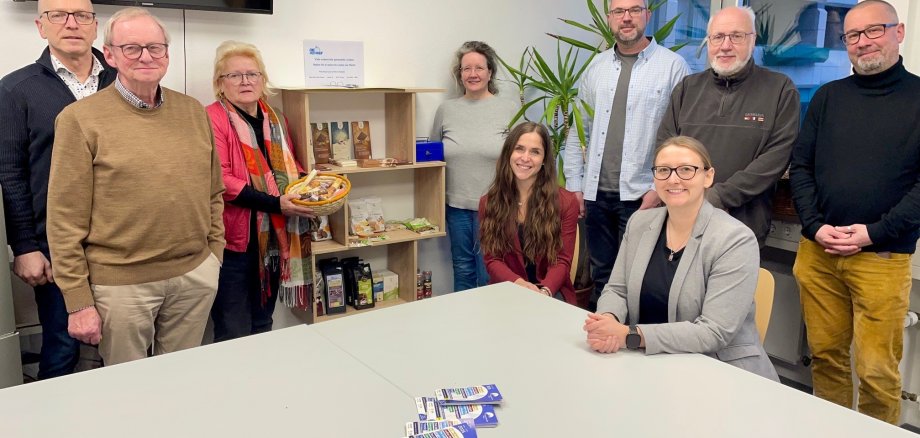 Verschiedene Personen stehen an einem Tisch