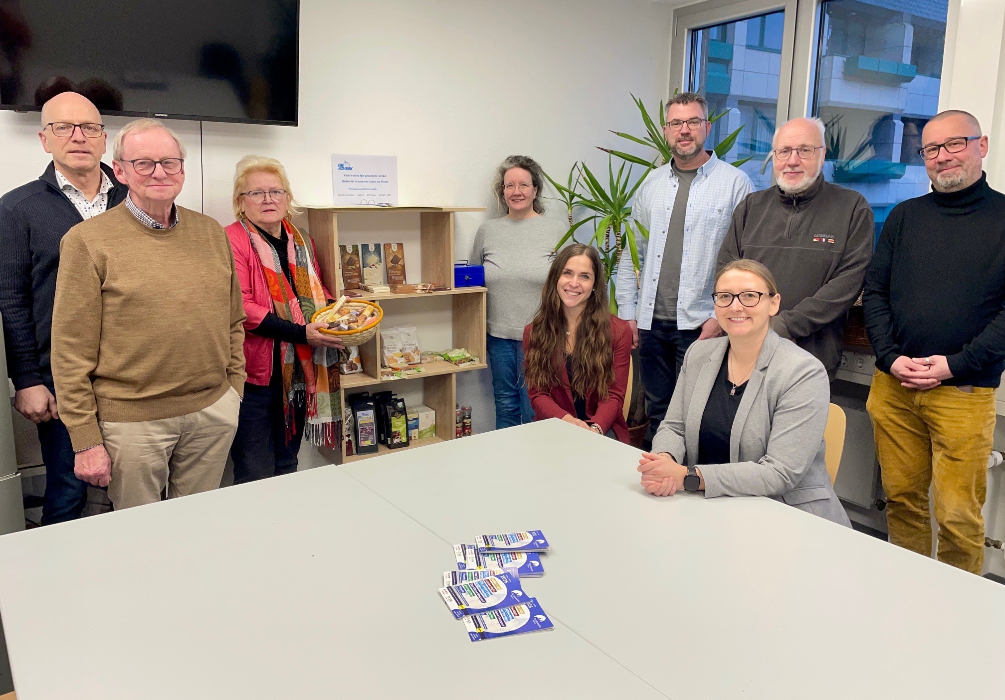 Verschiedene Personen stehen an einem Tisch