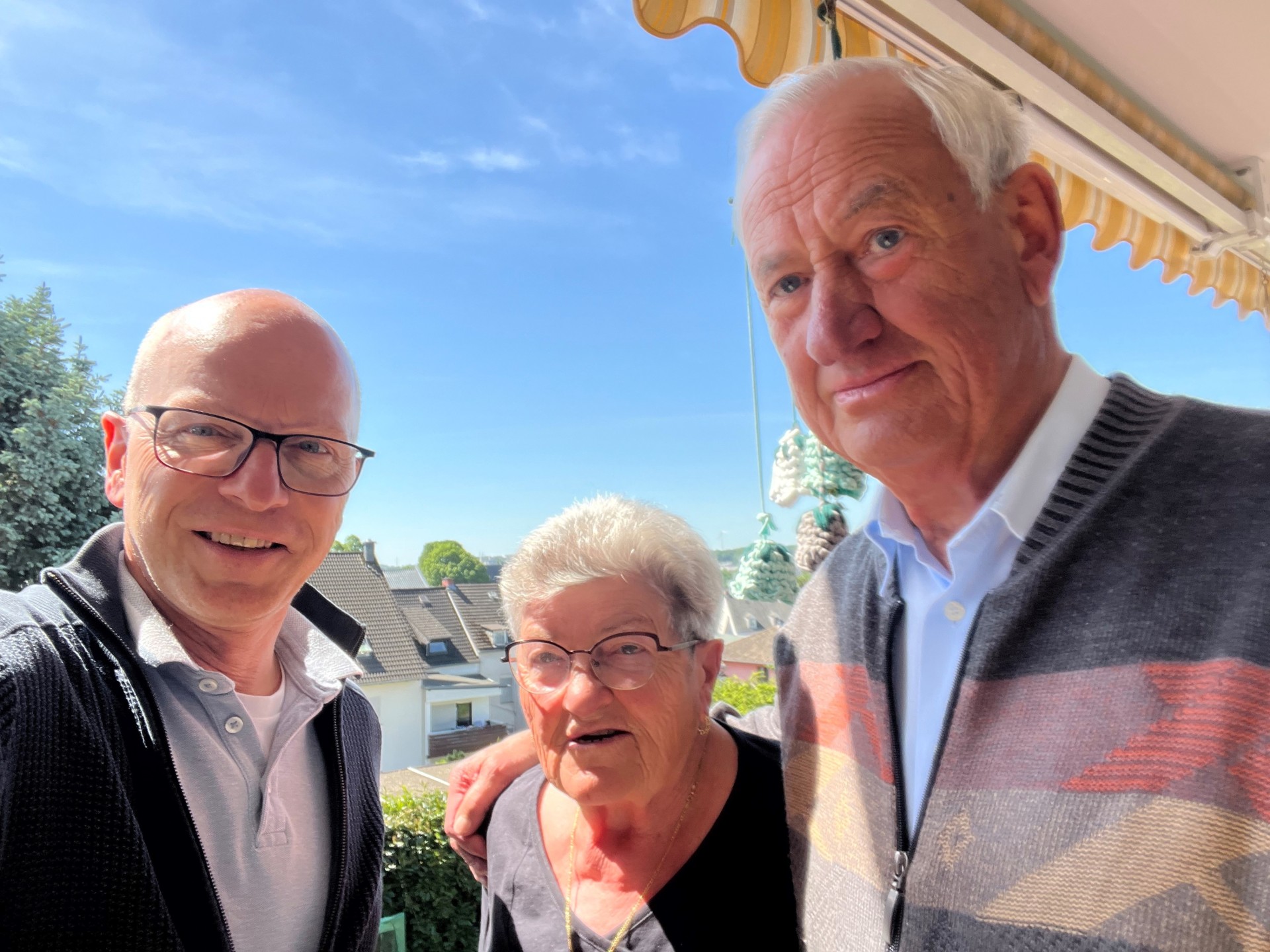 OB Meid posiert mit den Eheleuten Karbach draußen.