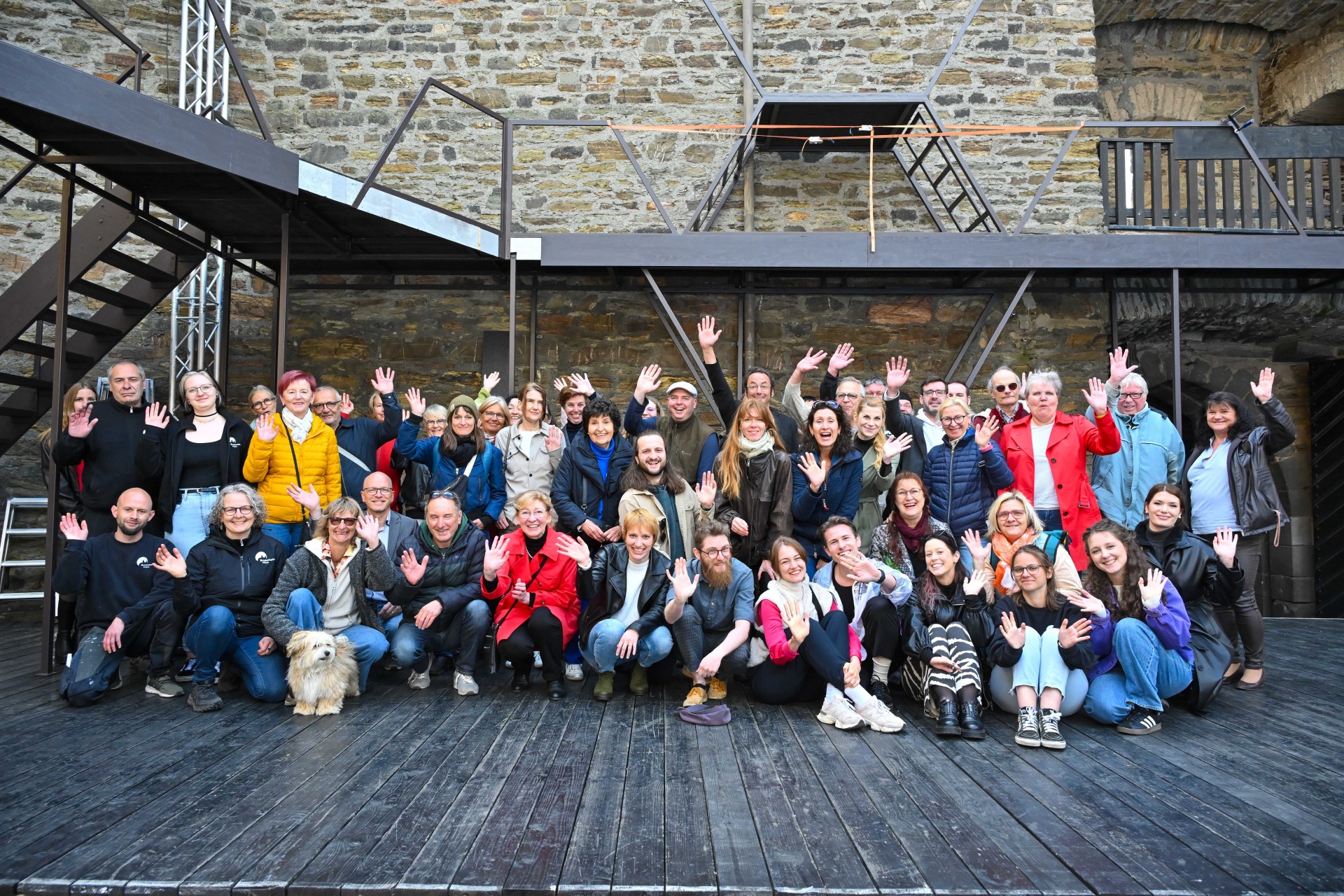 Viele Menschen posieren zusammen auf der Bühne der Burgfestspiele
