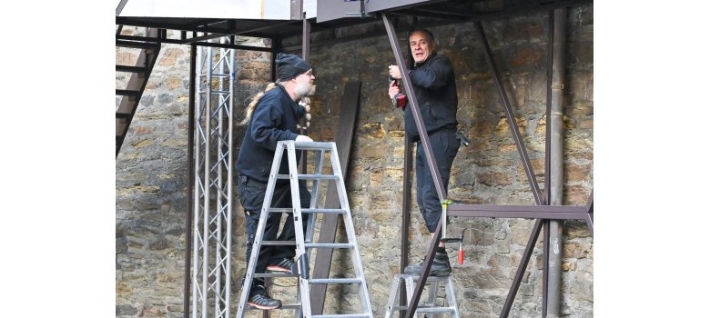 Zwei Arbeiter bauen Teile des Bühnenbilds auf