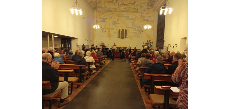 Zuschauer in einer Kirche verfolgen das Konzert