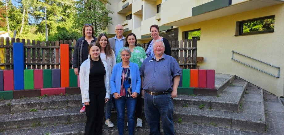 Acht Personen posieren auf einer Treppe