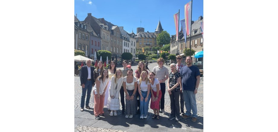 Die Studenten posieren gemeinsam mit Bürgermeister Mauel auf dem Marktplatz vor der Burg