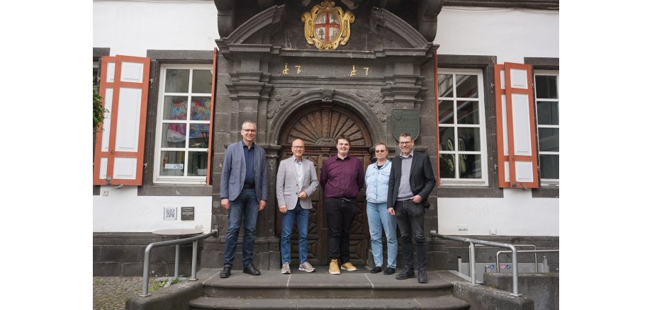 Fünf Personen stehen gemeinsam auf der Treppe vor dem Alten Rathaus 