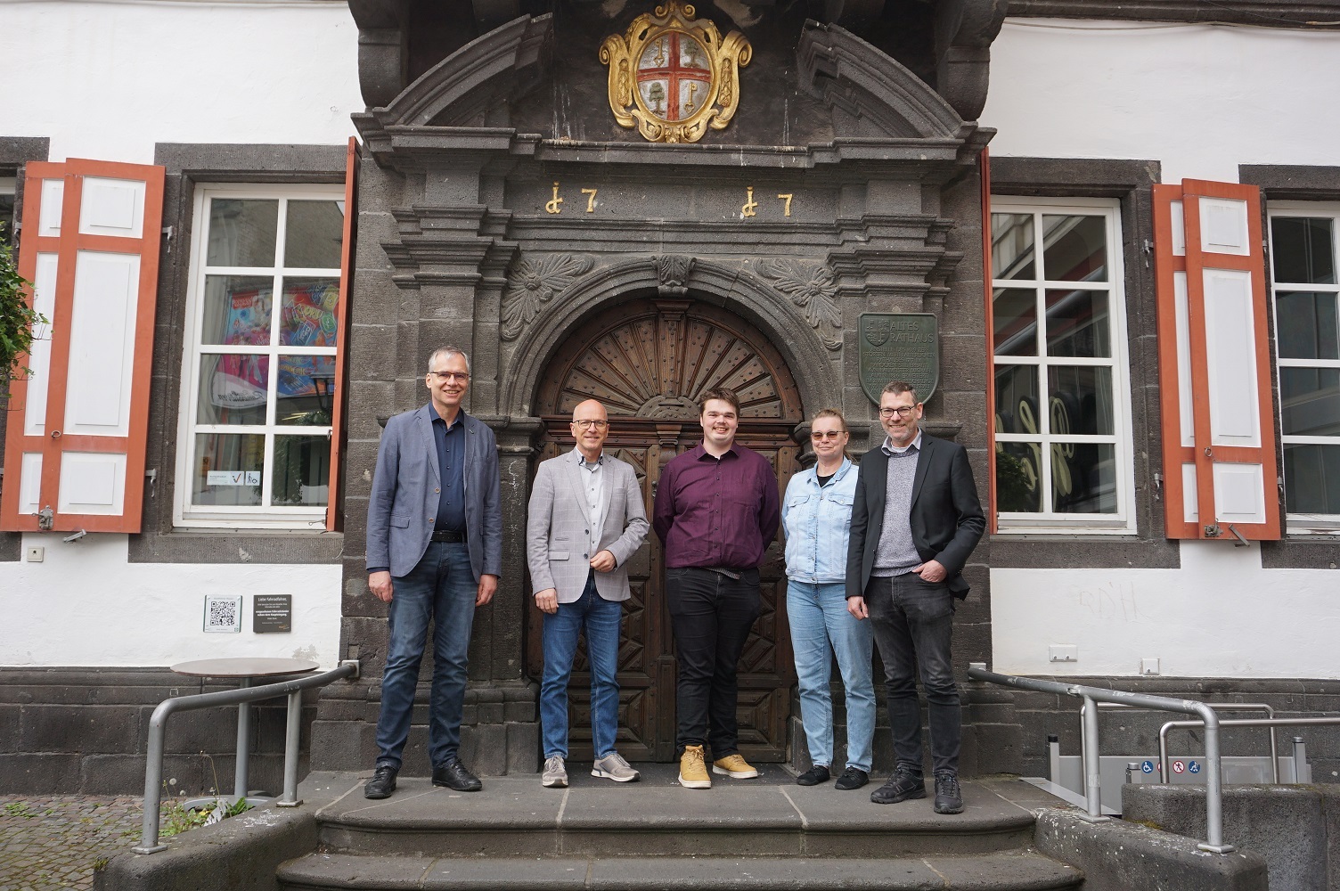 Fünf Personen stehen gemeinsam auf der Treppe vor dem Alten Rathaus 