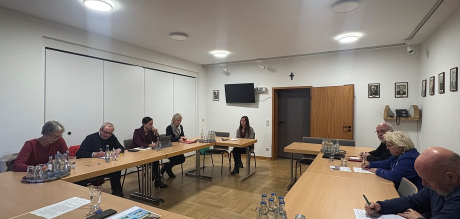 Mehrere Personen sitzen im Besprechungsraum