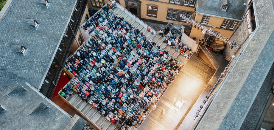 Der Kartenvorverkauf ist angelaufen Der Burginnenhof von oben mit vielen Zuschauenden