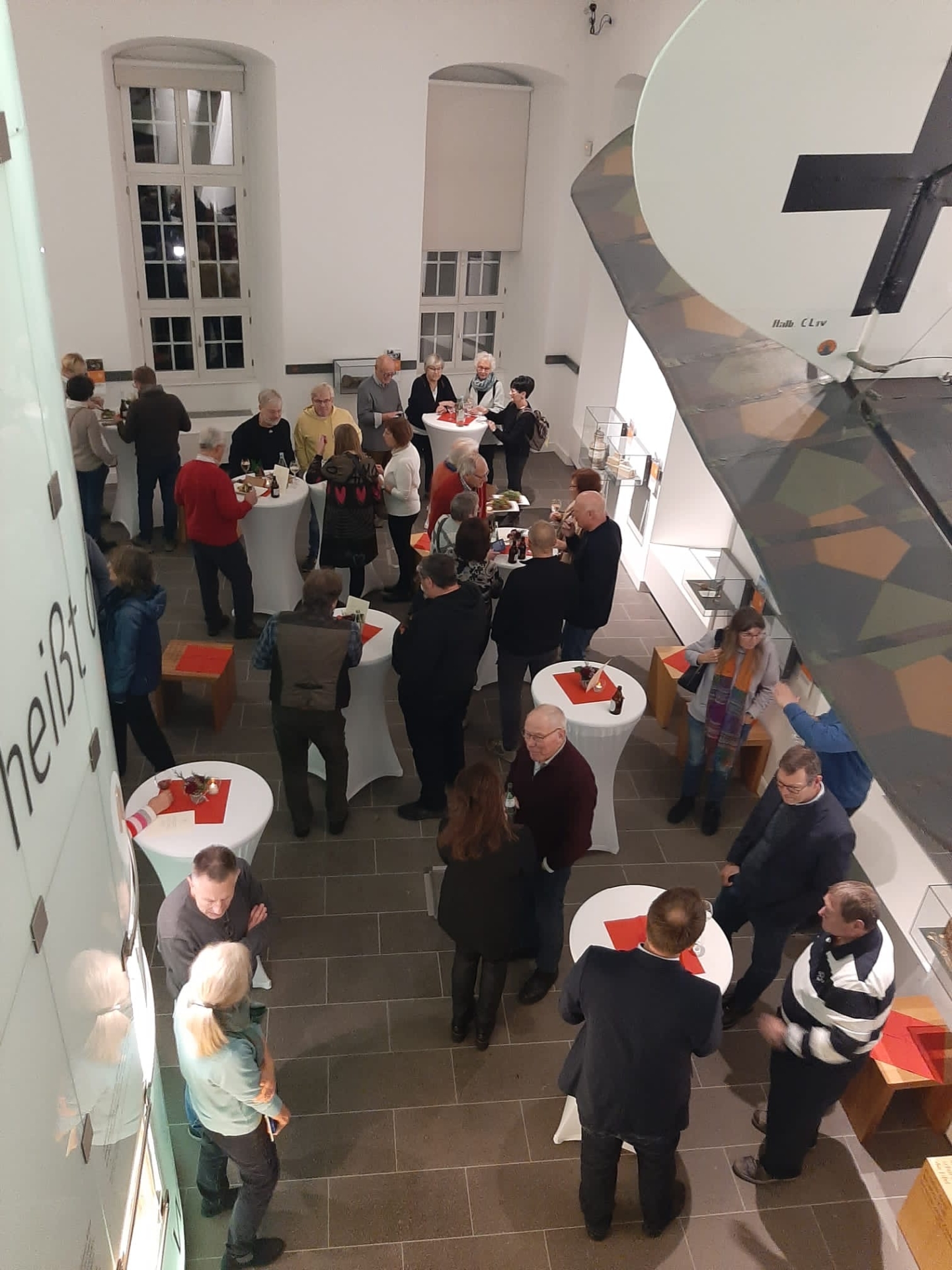 Viele Menschen stehen an verschiedenen Stehtischen im Eifelmuseum