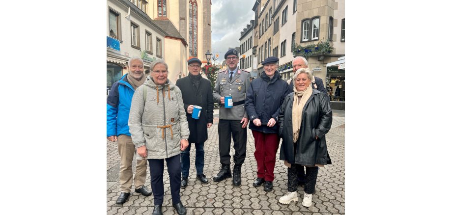 Sieben Menschen stehen gemeinsam in der Markstraße um Spenden zu sammeln.