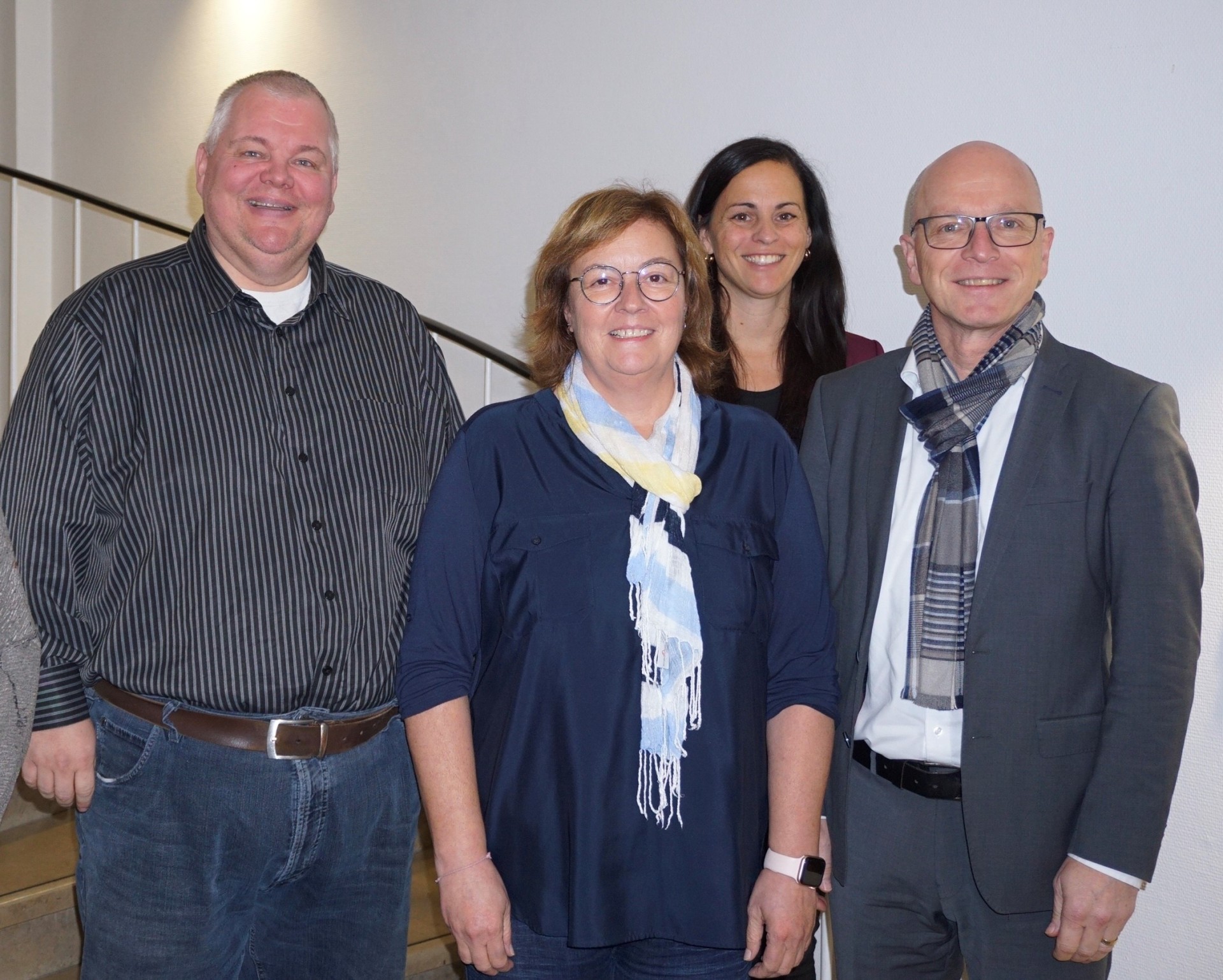 Personalratsvorsitzender Wolfgang Goeken, Fachbereichsleiterin Sandra Dietrich Fuchs, Büroleiterin Jasmin Alter und Oberbürgermeister Dirk Meid stehen gemeinsam auf einer Treppe im Rathaus.