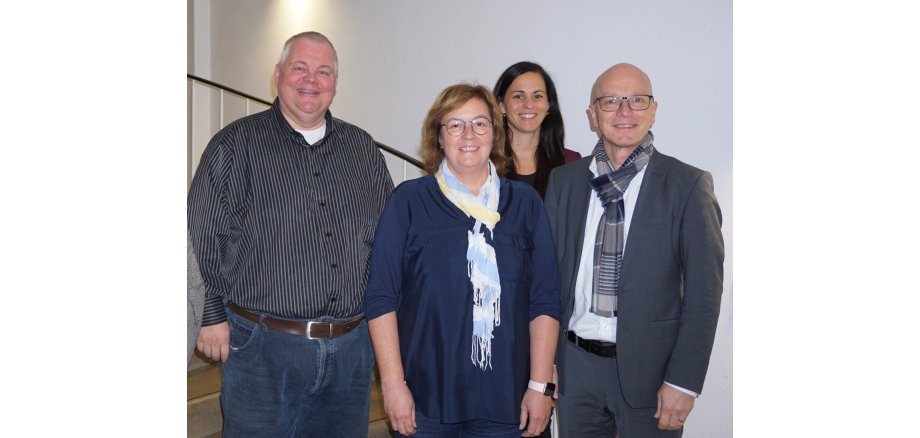 v.l.n.r.: Personalratsvorsitzender Wolfgang Goeken, Fachbereichsleiterin Sandra Dietrich Fuchs, Büroleiterin Jasmin Alter und Oberbürgermeister Dirk Meid Personalratsvorsitzender Wolfgang Goeken, Fachbereichsleiterin Sandra Dietrich Fuchs, Büroleiterin Jasmin Alter und Oberbürgermeister Dirk Meid stehen gemeinsam auf einer Treppe im Rathaus.