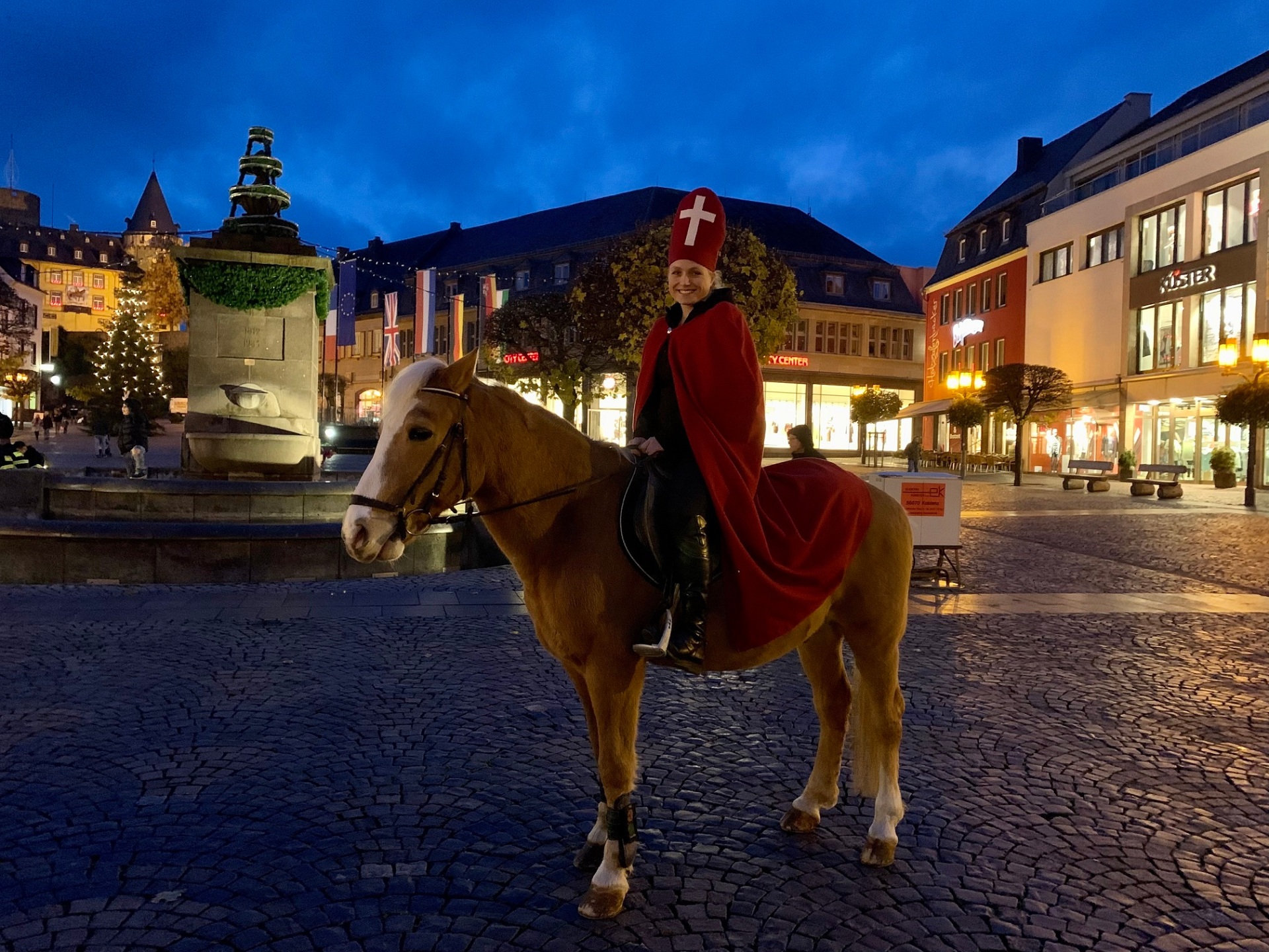 Martinsdarstellerin Alina Rübenach sitzt im Martinsgewand auf einem Pferd.
