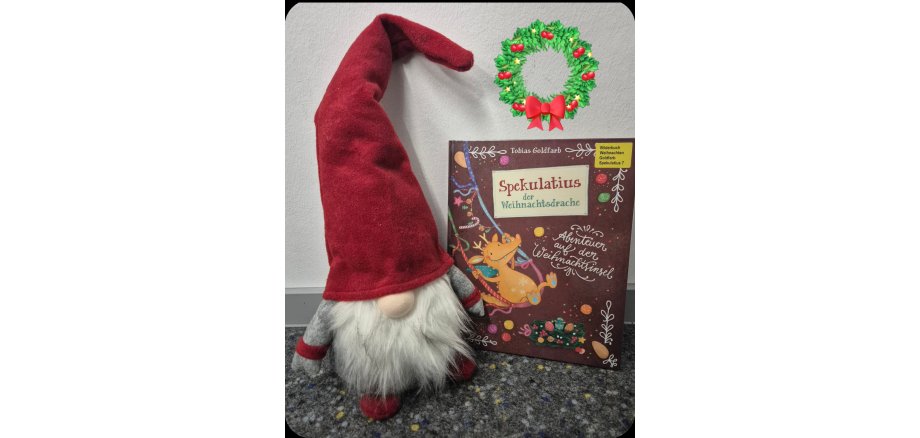 Ein Deko Weihnachtswichtel sitzt neben einem Kinderbuch