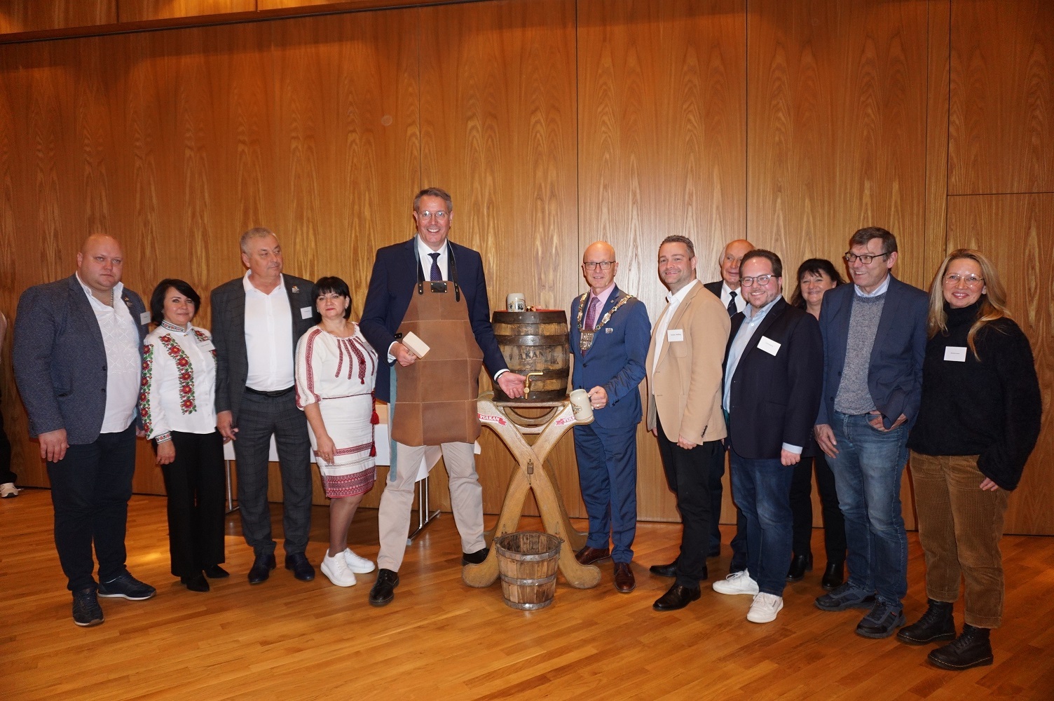 Mehrere Personen stehen um ein Fass für einen Fassanstich