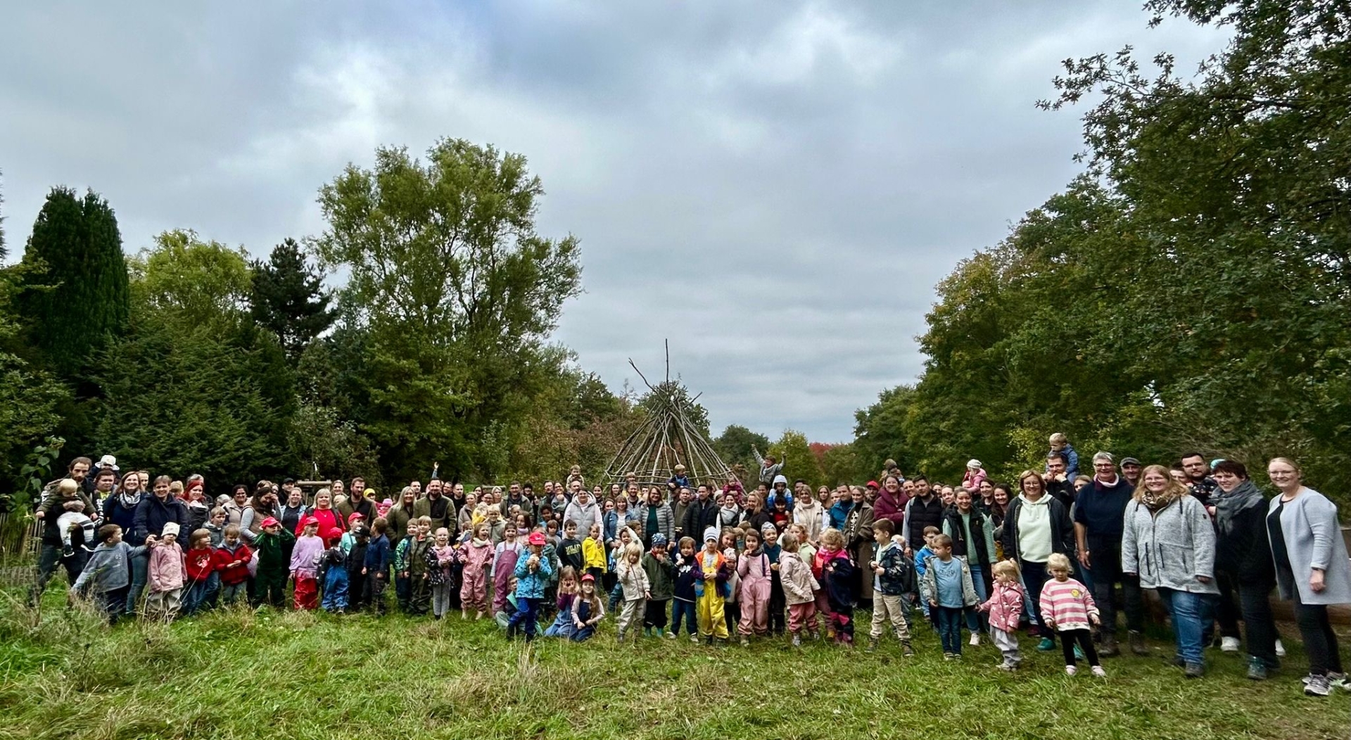 Mehrere Kinder aus den städtischen Kitas Mayen stehen oder sitzen in der Natur. Sie sind von Bäumen und Grün umgeben und nehmen an einer Aktion im Rahmen der Gesundheitswoche teil.