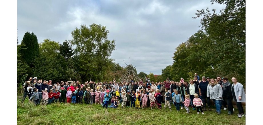 Mehrere Kinder aus den städtischen Kitas Mayen stehen oder sitzen in der Natur. Sie sind von Bäumen und Grün umgeben und nehmen an einer Aktion im Rahmen der Gesundheitswoche teil.