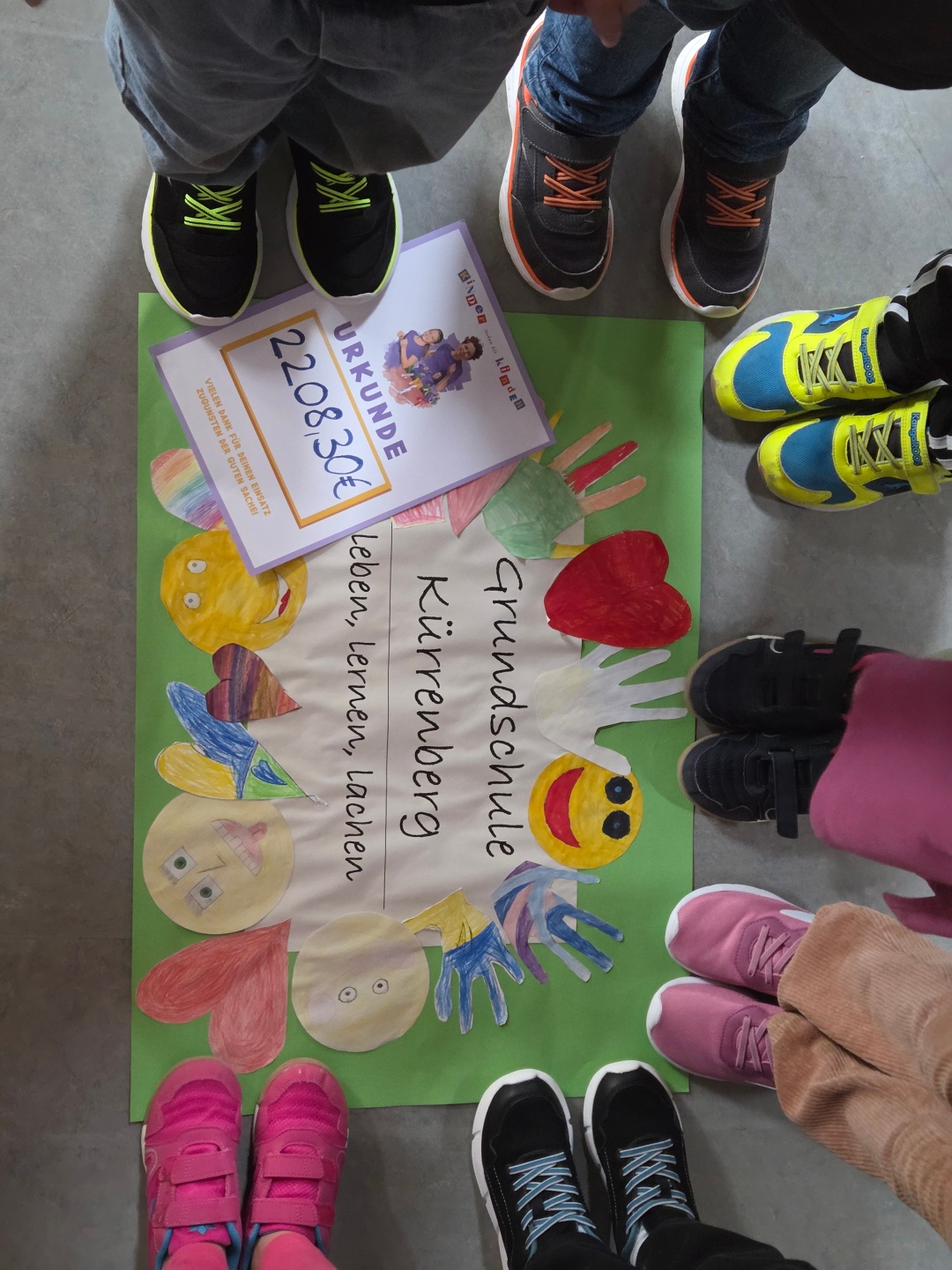 Kinderfüße im Kreis um ein Plakat