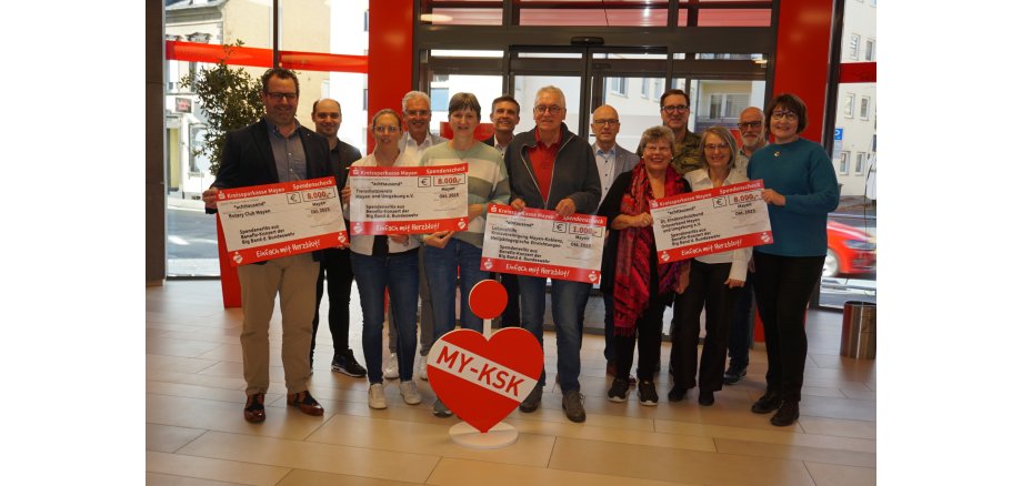 Vertreterinnen und Vertreter der begünstigten Organisationen halten alle jeweils einen Spendencheck in der Hand