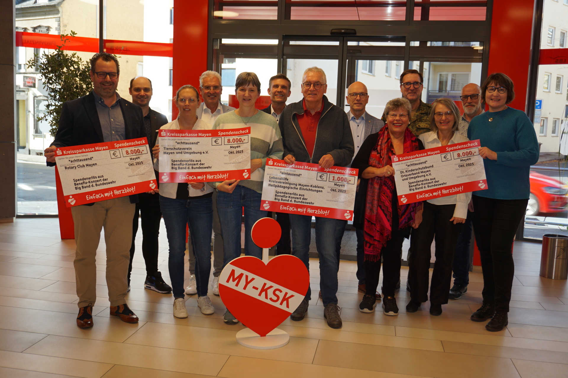 Vertreterinnen und Vertreter der begünstigten Organisationen halten alle jeweils einen Spendencheck in der Hand