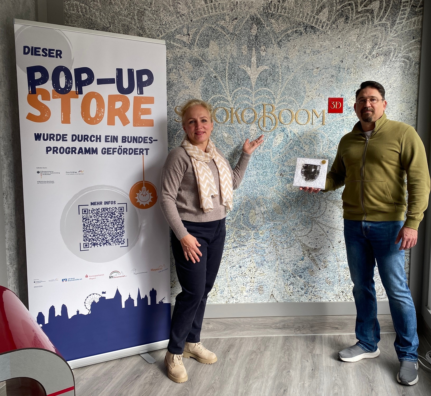 Herr und Frau Smyrnov stehen gemeinsam in ihrem Geschäft