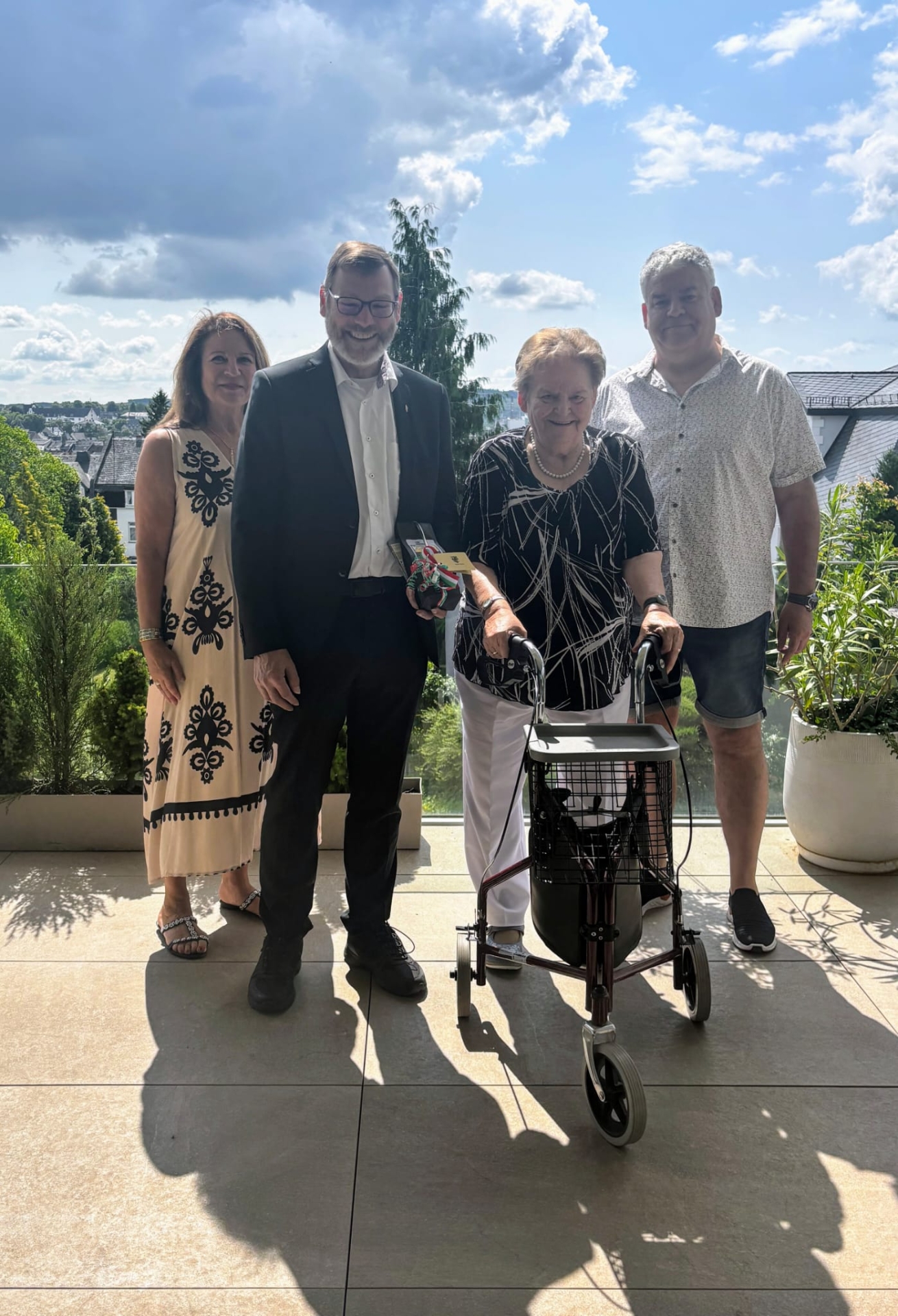 4 Personen stehen um das Geburtstagskind