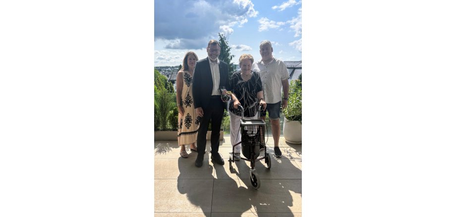 4 Personen stehen um das Geburtstagskind