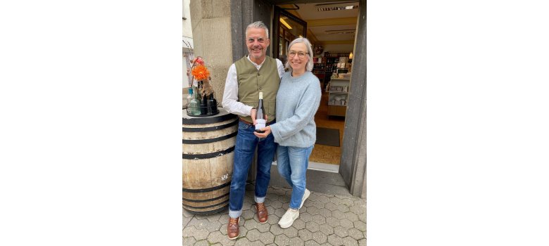 Den Lukasmarktwein gibt es beim Fachgeschäft Schwindenhammer Die Besitzer des Fachgeschäfts halten gemeinsam den Wein in der Hand