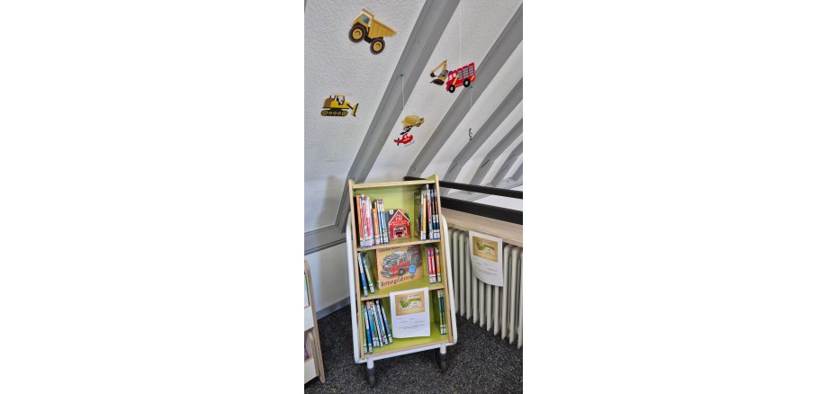 Bücherregal mit vielen Kinderbüchern und Feuerwehrdeko