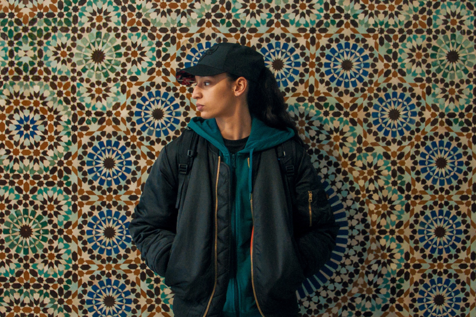 Eine Frau steht vor einer Wand und schaut nach links